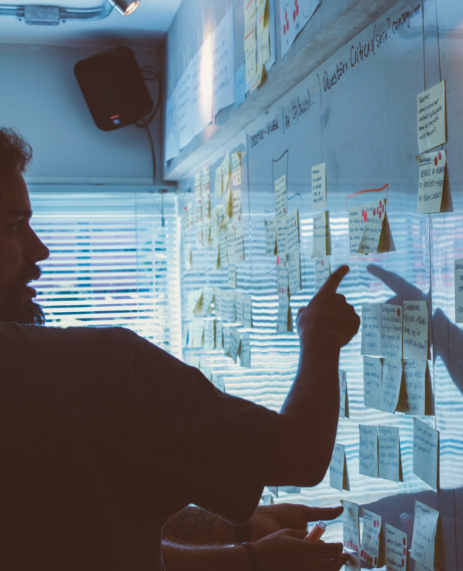 Future of work post-pandemic: People discussing a problem in front of a whiteboard.